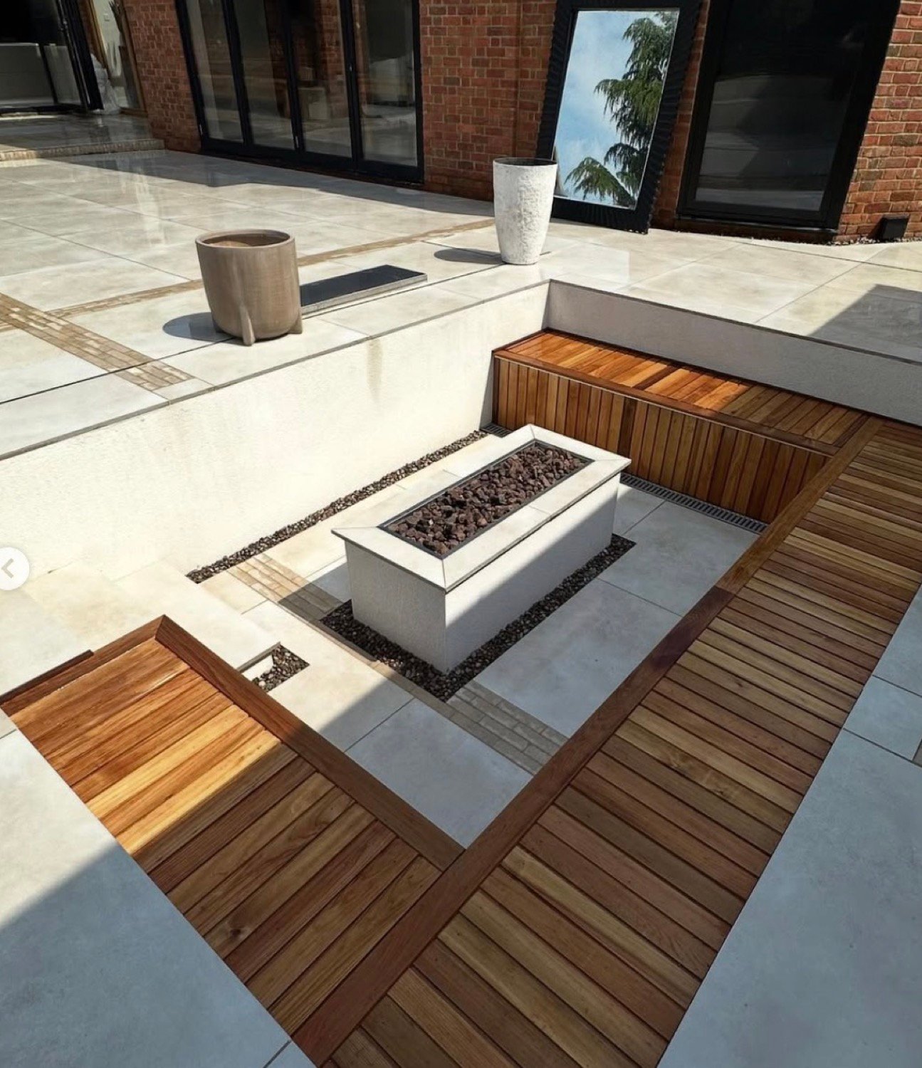 Sunken seating area with a gas firepit and hardwood benches